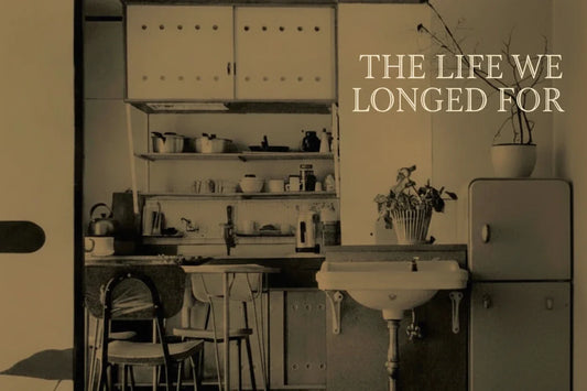 Book cover of 'The Life We Longed For' by Laura Neitzel with a kitchen scene.